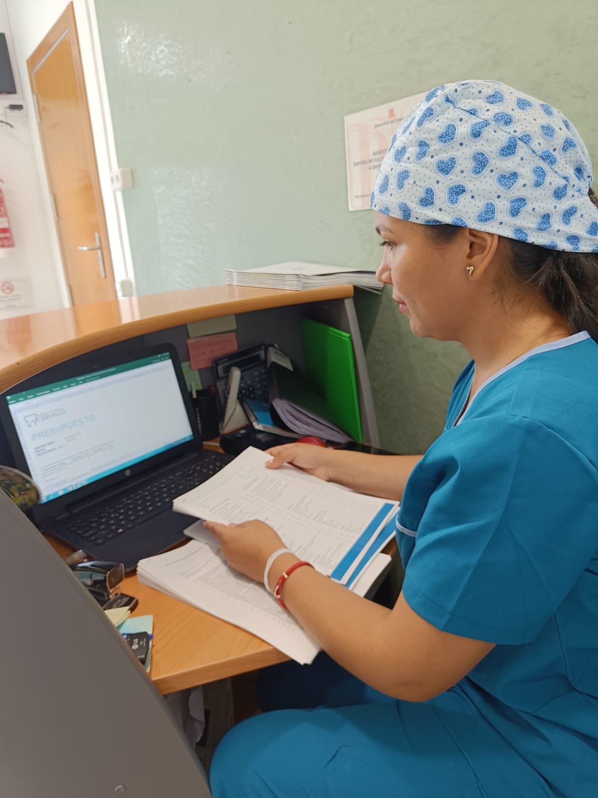 Profesional de Clínica Dental Cervelló revisando documentación en recepción